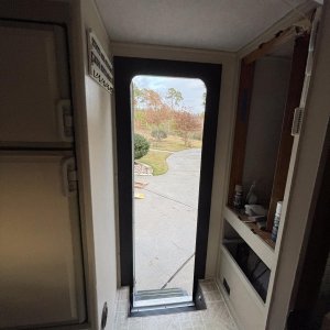 removed broken old plastic door frame, insulated and trimmed out with lumber, then painted it black.