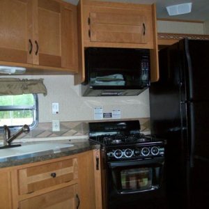 Sink with pull out faucet, Gas stove and oven, magic chef microwave and range hood, full size fridge with ice maker