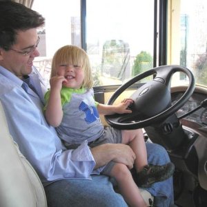 My grandson at the wheel with his dad.