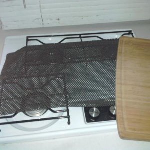 Believe it or not, this is all that is required to keep the cutting board on the stove during travel.  Love it!