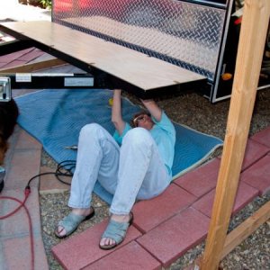 I these three pictures, my wife Linda is helping me install the polyurethane coated plywood surface that our tool box will be mounted onto.