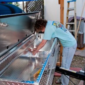 Linda is now bolting the Delta Champion tool box that I ordered 'freight damaged' on-line to the plywood board. As it turned out, the damage was easil