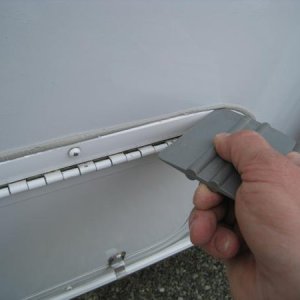 I used a plastic squeegee to trim the excess butyl tape.
(Plastic squeegee will not harm the fibreglass)