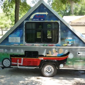 Left side of trailer faces traffic. Front wheel of street rod is 16" pizza pan. Side pipe is modified handrail salvaged from handicapped restroom. Beh