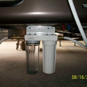 The Dual Filter Mount slides onto bolts on an aluminum angle bracket that is fastened to the RV back under the RV at the Frame.  This sets it back und