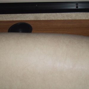 Behind the couch.  There are three cup holders.  If you have a cat, there is room for the cat to "sneak" behind the couch using this part in the corne