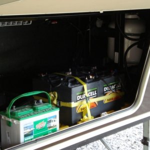 Outgoing battery (green), new Duracell 6 volt in place secured together and onto camper frame.