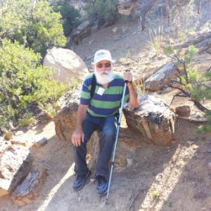 Ken sitting on petrified wood,  UT