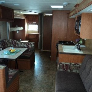 Dinette table in front of kitchen area along side jack knife couch