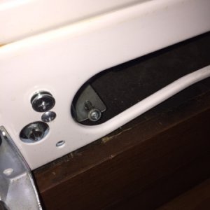 There is one screw on each side of the fridge bottom which anchors it to the floor.  Remove both with the freezer door open and kickplate removed.