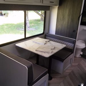 dinette with big window and sink cover/counter laying on table.  It turns into a small bed.