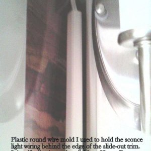 This shows the round plastic wire mold I routed the sconce light wires in.  I then placed this behind the edge of the slide-out trim and firmly presse