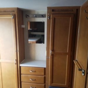 Cabinets and "vanity" in back of trailer. Entrance to the left and wet bath to the right.