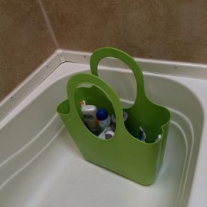 Dollar store plastic basket sits in the tub with shower goodies, extra sunscreen, etc inside.