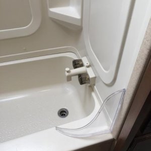 Curved plastic tub/shower guard.