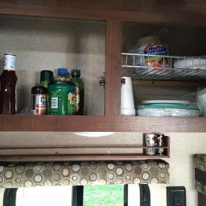 Spice rack above the window and shelves in the overhead cabinets.