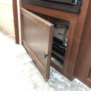 Added hinges and a door knob on the panel under the refrigerator for easier access.