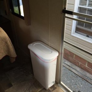 I found the perfect trash can at Lowe's. It is very narrow and not in the way when walking into the bedroom.