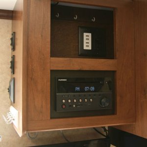 I created a charging station above the radio. The usable space behind the panel was easily modified with a duplex outlet and USB charge block.