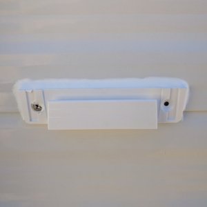 Bracket for removable motion sensing solar lights. This one was mounted with a stainless screw and 3M tape as the paneling was bowing out here and thi