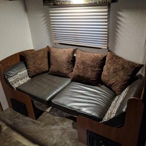 Dinette in couch mode with pillows.  Table wall mount t bracket cover also installed behind pillows.