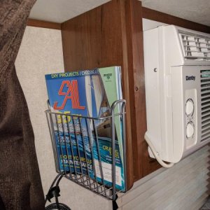 Magazine rack on the side of the AC unit over queen bed.  Used to hold reading material and phone charging cords.