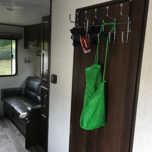 Put a simple over-the-door rack on bathroom. It’s great for coats, dog leash, flashlight etc. Put felt pad on inside to prevent scratching door.