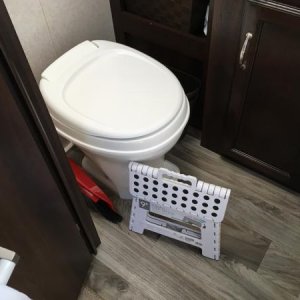 Stool folds flat and tucks next to toilet.