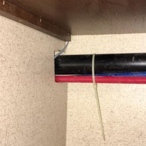 Wires drop down back corner of pantry shelves and then run horizontally along plumbing lines next door to bathroom sink cabinet