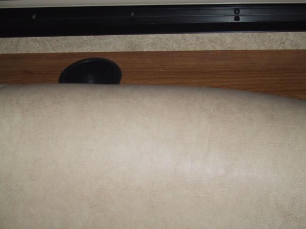 Behind the couch.  There are three cup holders.  If you have a cat, there is room for the cat to "sneak" behind the couch using this part in the corne