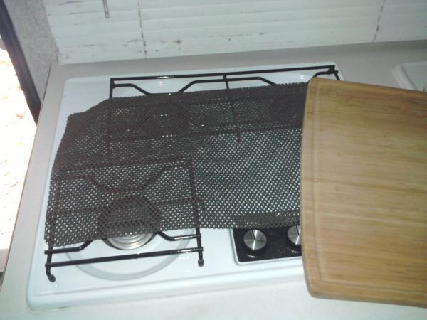 Believe it or not, this is all that is required to keep the cutting board on the stove during travel.  Love it!