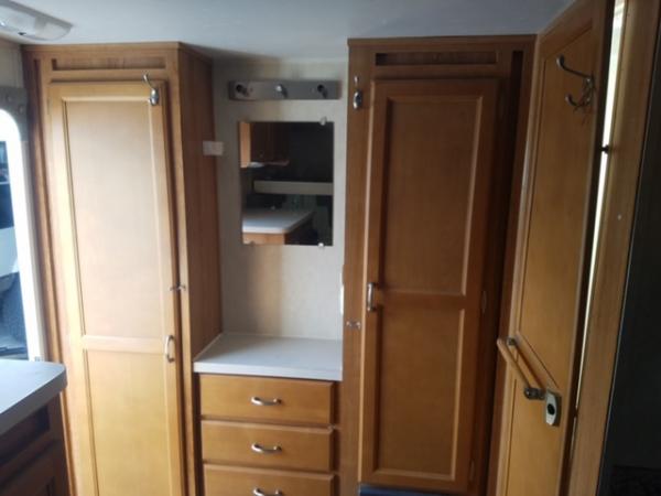 Cabinets and "vanity" in back of trailer. Entrance to the left and wet bath to the right.