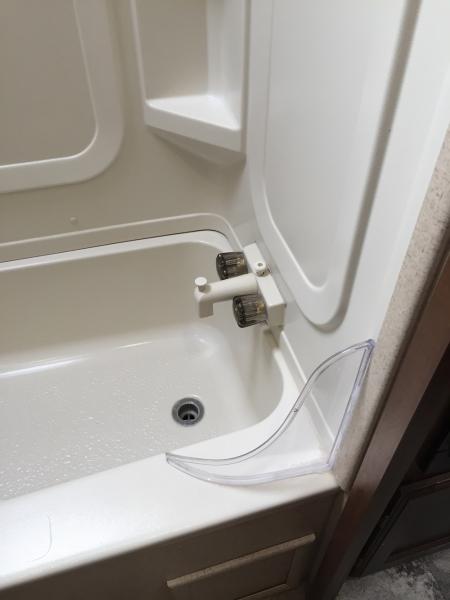 Curved plastic tub/shower guard.