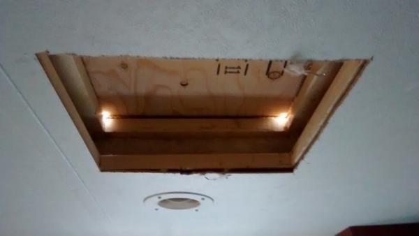 Cut hole in bedroom ceiling and drilled corner holes through roof.