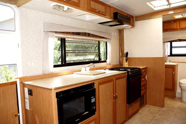 Day/night shades, ample counter space, microwave, dual sink/cover, 3 burner stove/oven, overhead vent, plenty of storage.