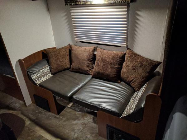 Dinette in couch mode with pillows.  Table wall mount t bracket cover also installed behind pillows.