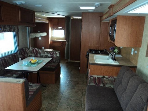 Dinette table in front of kitchen area along side jack knife couch