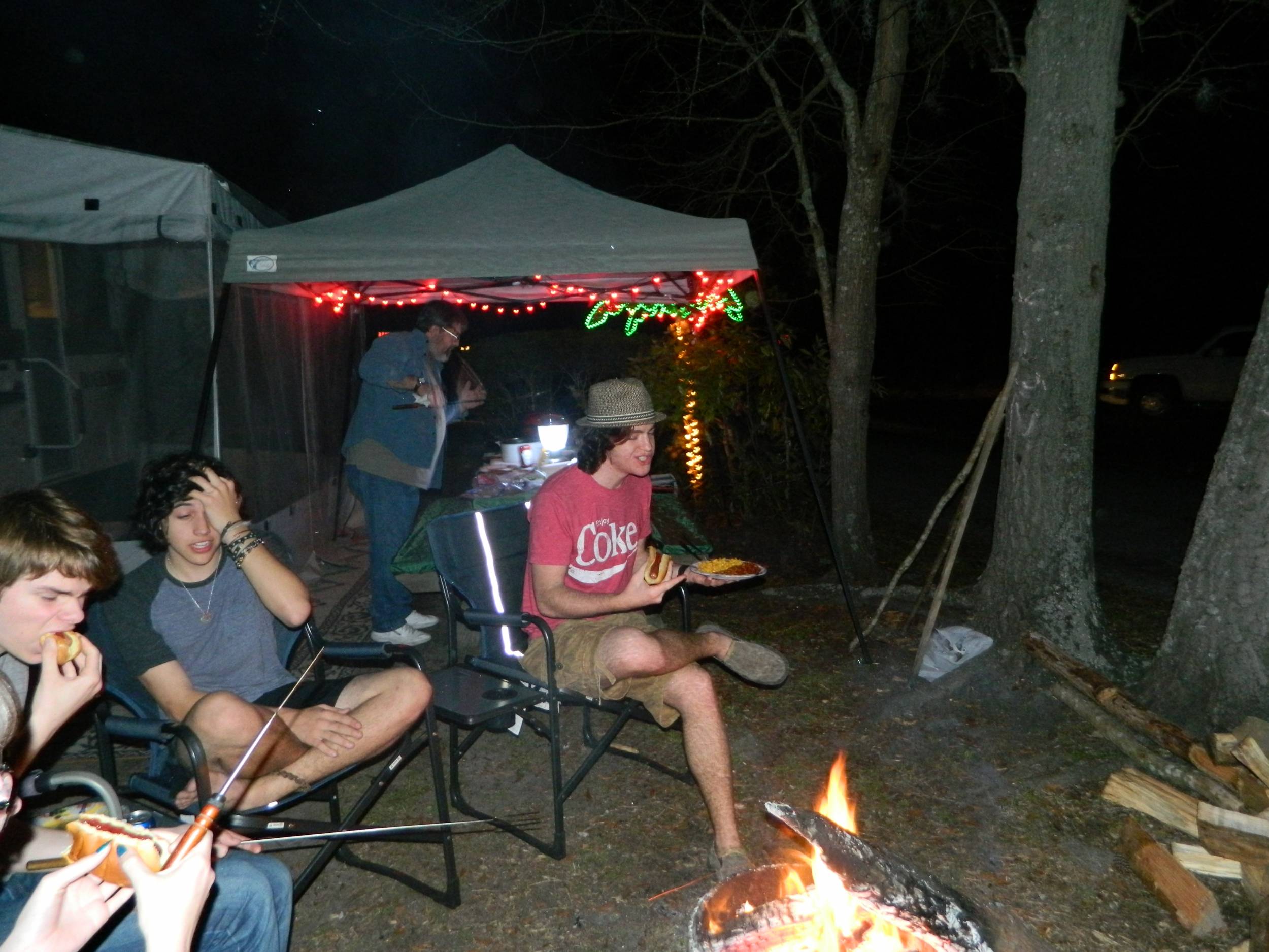 Enjoying food and fire at night.