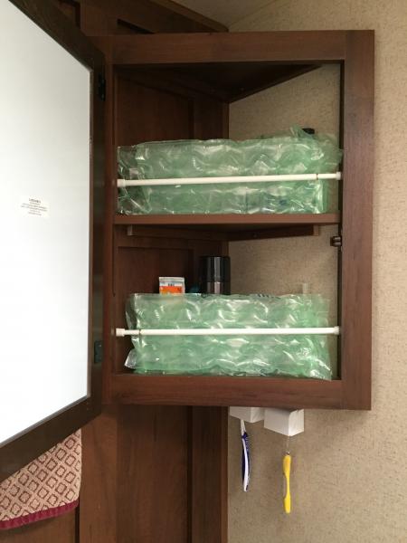 For traveling purpose only, we use an expandable curtain rod along with packaging bubbles to keep items in the medicine cabinet upright.