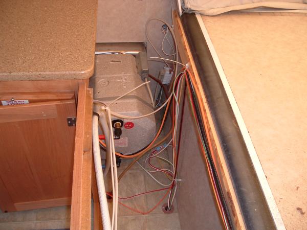 Front Shelf 5: View over water heater with shelf removed.  It is that vanity cover that will have to be loosened (unscrewed and some staples removed) 