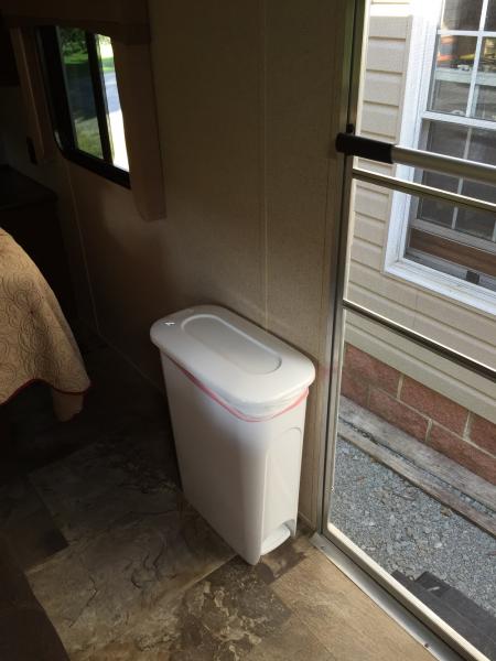 I found the perfect trash can at Lowe's. It is very narrow and not in the way when walking into the bedroom.