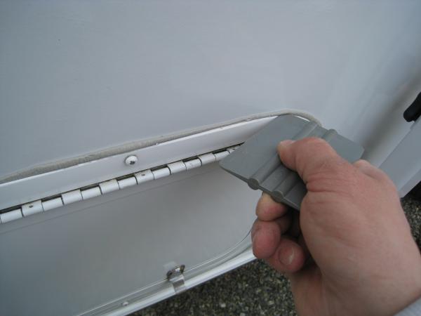 I used a plastic squeegee to trim the excess butyl tape.
(Plastic squeegee will not harm the fibreglass)