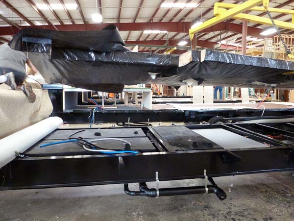 In the Forest River factory. The frame for the floor is about to be lowered onto the chassis.