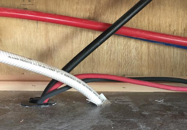 Inverter wiring goes behind panel and passes through hole for water heater gas line