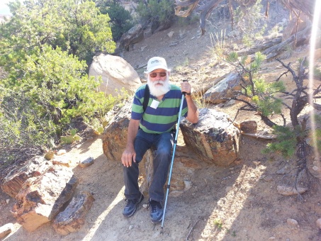 Ken sitting on petrified wood,  UT