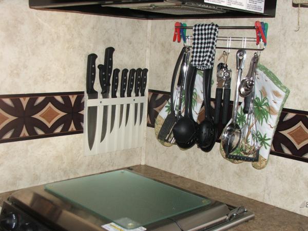 Knife holder (campers world) and hooks (not sure where I got this)for spatula, big spoons, etc. Added a clear cutting board to stove top to use and he