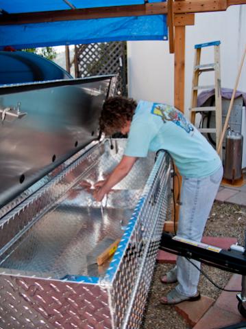 Linda is now bolting the Delta Champion tool box that I ordered 'freight damaged' on-line to the plywood board. As it turned out, the damage was easil