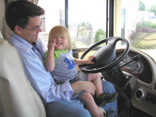 My grandson at the wheel with his dad.