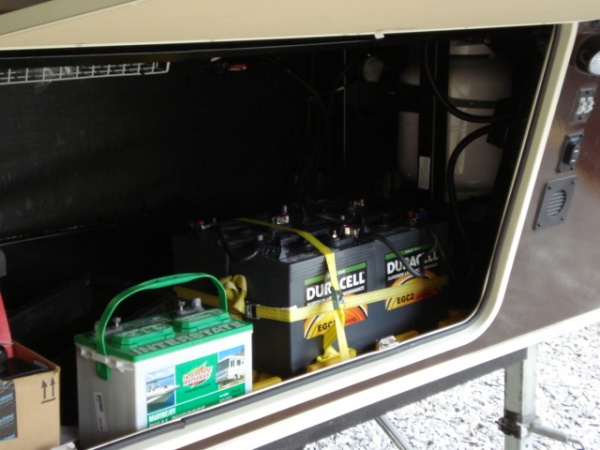 Outgoing battery (green), new Duracell 6 volt in place secured together and onto camper frame.