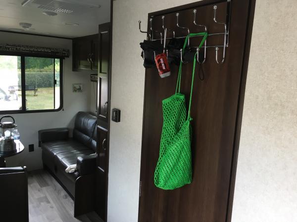 Put a simple over-the-door rack on bathroom. It’s great for coats, dog leash, flashlight etc. Put felt pad on inside to prevent scratching door.